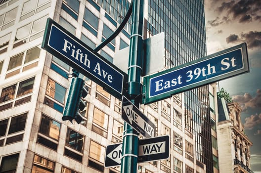 Fifth Ave 5th Ave, New York City sign, view from low angle with sunset and skyscraper in background, usa