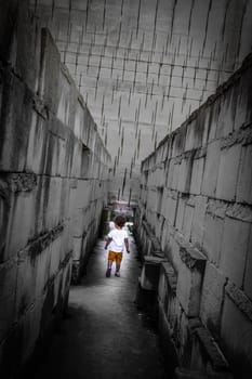 Caucasian young kid walking with labyrinth perspective. Conceptual image for dangerous situation during childhood.