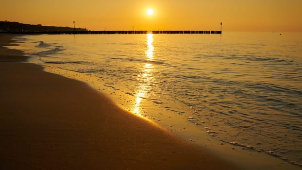 Sunset on the beach of Kolobrzeg on the coast of the Baltic Sea in Poland