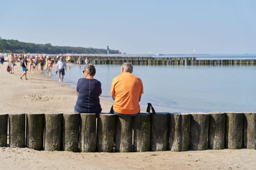 Couple on a breakwater on the beach of Kolobrzeg on the Baltic Sea in Poland