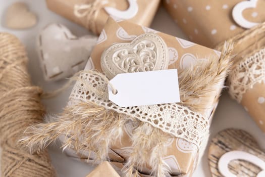 Valentines present with horizontal gift tag, heart and pampas grass close up. Spring scene with blank label. Rustic, cottage chic or bohemian mockup, copy space