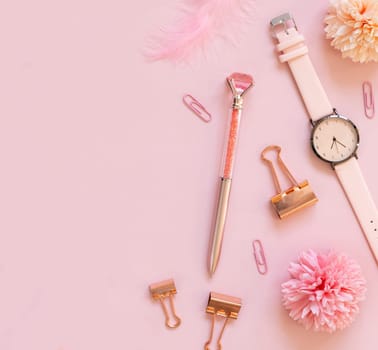 Pink school accessories and stationery on pastel pink background Top view, copy space. Girly workplace with watch, pen, paperclips, flowers and feathers. Back to school concept