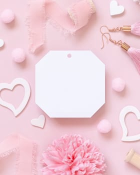 Blank paper gift tag, hearts, flowers, silk ribbons and tassel earrings on pink top view. Romantic scene with blank label mockup flat lay. Valentines day, wedding and girly concept.