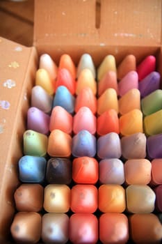 A box of colored crayons not yet touched by babies and ready to play
