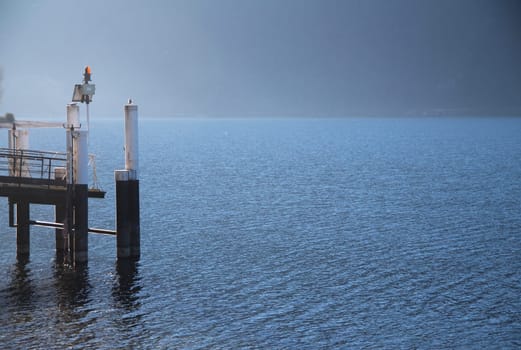 The ferry boat docking station of Abbadia Lariana during a winter sunrise on Como Lake in Italy