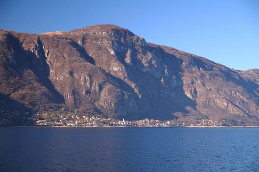 Caption of Oliveto Lario and the alps above taken from Abbadia Lariana on Como Lake in Italy