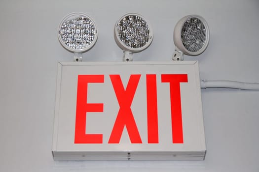 The flashing red security exit sign with three powerful lights on the exit of a building