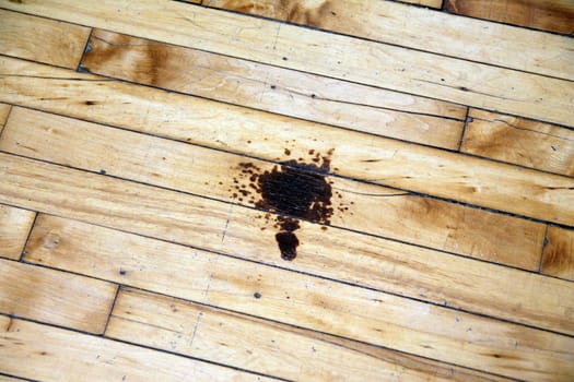 A stain on the brown wooden floor of an industrial space in the United States of America