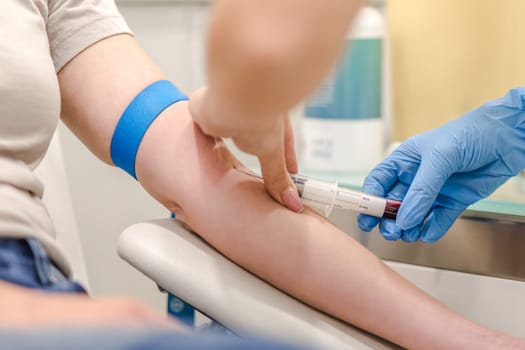 Close-up Of Doctor Taking Blood Sample From Patient's Arm in Hospital for Medical Testing