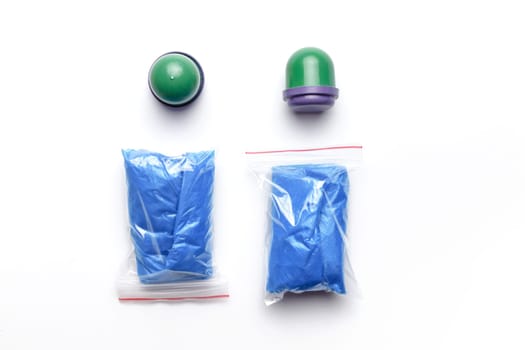 Two different packed shoe covers for shoes on a white background, top view.