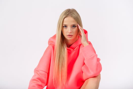 Young pretty woman wearing yellow hoodie and gray cycling shorts on white background. Casual women sport look