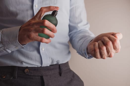 Man in formal wear holding perfume bottle, closeup. Space for text