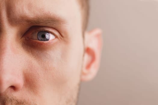 Young worried man with stern look. Sad expression. Close-up portrait half face. Mental health