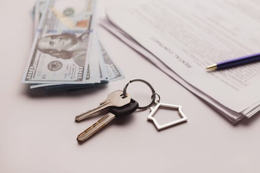 Real estate purchase contract with money and home keys on white table. Rental deal business trip living long term rental. Payment cash