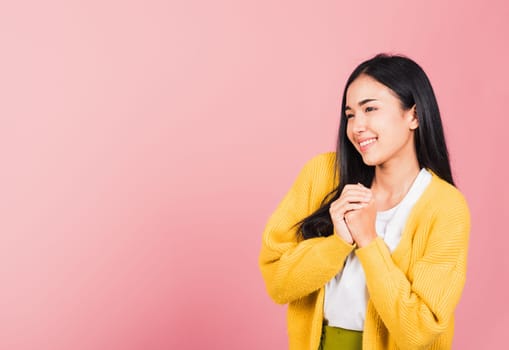 Happy Asian portrait beautiful cute young woman teen stand excited expression fist pressed together under chin pleased and delighted, thanking help studio shot isolated on pink background