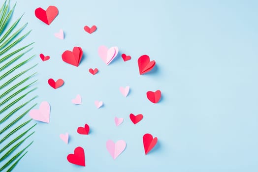Valentines' day background. Pattern beautiful red paper hearts cut composition greeting card isolated on blue background with copy space, Symbol of love Top View from above