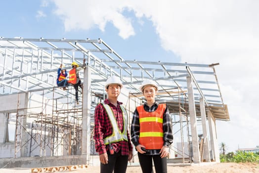 Architect and client standing at home building construction site. Portrait Asian engineer foreman worker man and woman in hardhat posing on building, Concept for team work