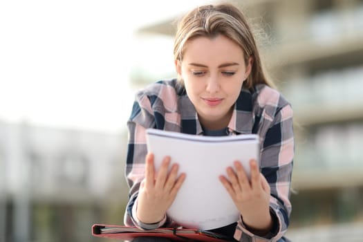 Student studying reading notes outdoors