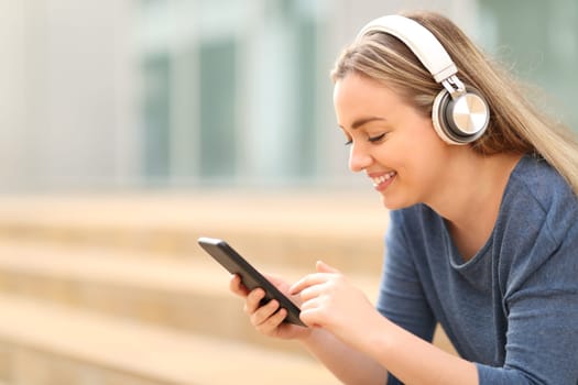 Happy teen listening to music in a campus