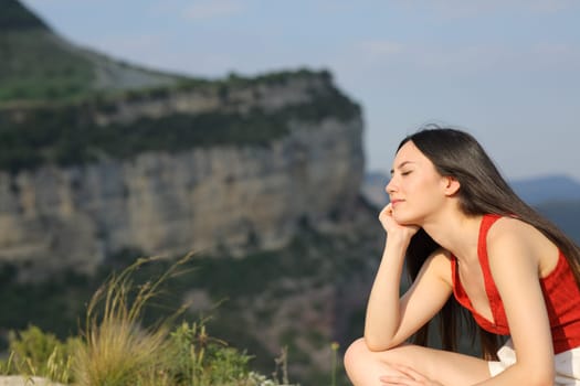 Asian woman in red resting in the mountain