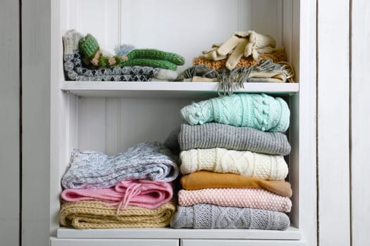 Knitting clothes and yarn on wooden background