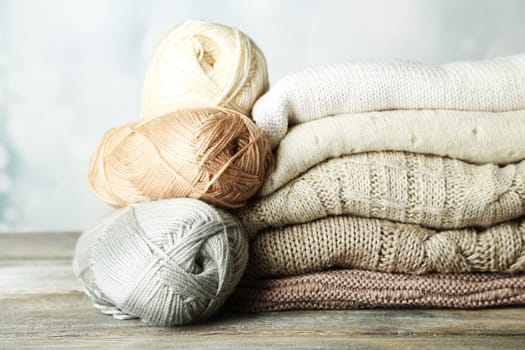 Knitting clothes and yarn on wooden background
