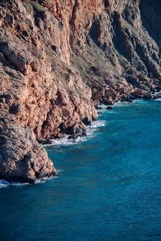 Landscape sea and rocks. The sea is an amazing blue color with different shades. The surf breaks the waves on the rocks.