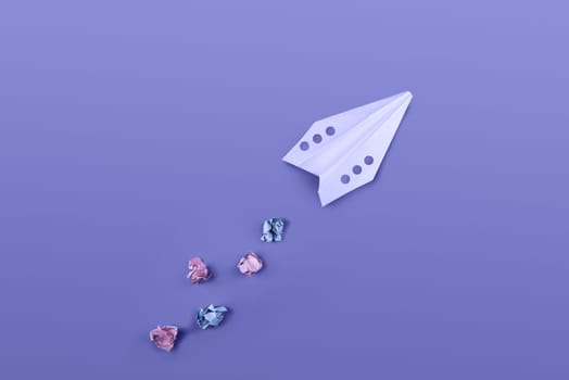 Flat lay of color paper plane colored in trendy violet color.