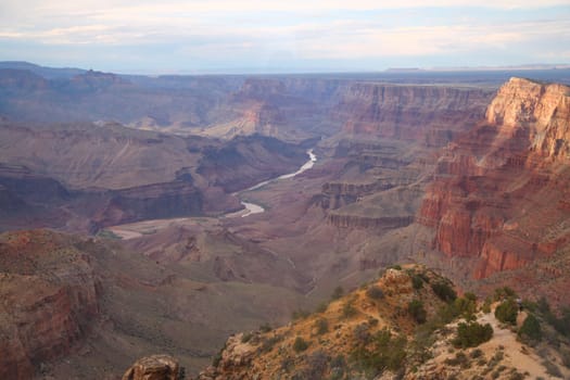 The far Colorado river flowing in the middle of the Grand Canyon National Park from a high view point in Arizona