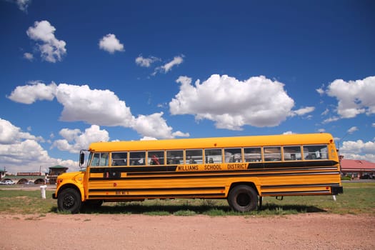 A traditional yellow school bus running its service in the desert of Arizona
