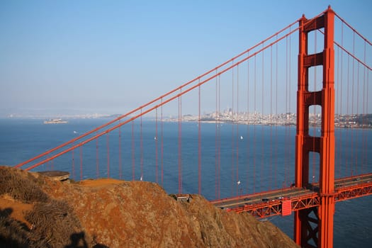 The red of the Golden Gate bridge with the blue of the ocean and the brown of the soil in San Francisco in California