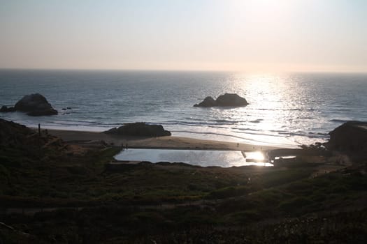 A yellow sunset over the ocean on Sutro Baths in San Francisco in California