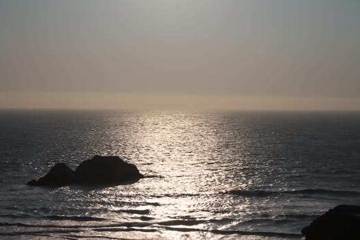 A yellow sunset over the ocean on Sutro Baths in San Francisco in California