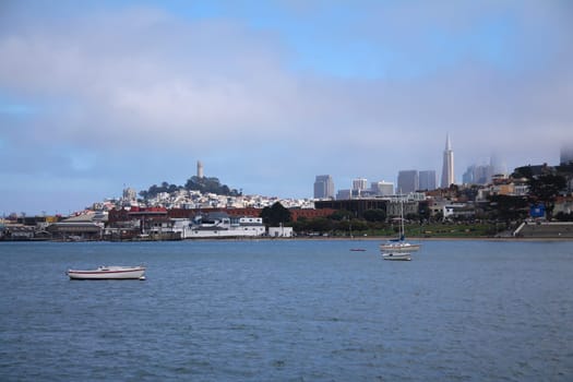 San Francisco skyline from the Fishermans Warf wit the Coit tower on top of the hill and boats in front, California