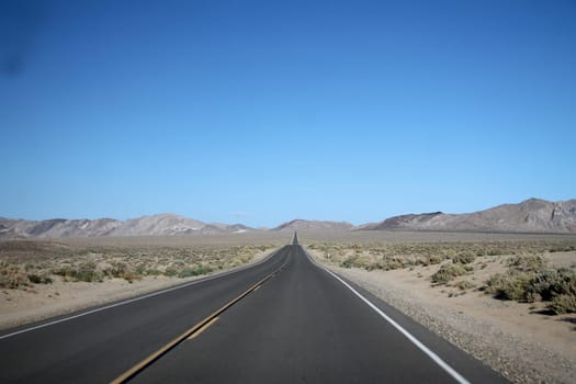 Endless road in the middle of the Death Valley Desert in California