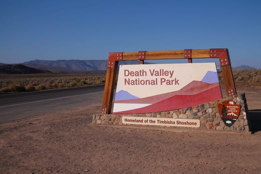 Entrance sign to Death Valley National Park during hot sunset in California