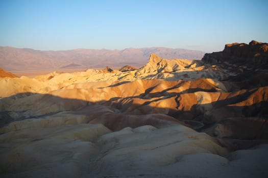 The sun of the morning highlights the dunes and colors of Zabriskie Point in the Death Valley desert in California