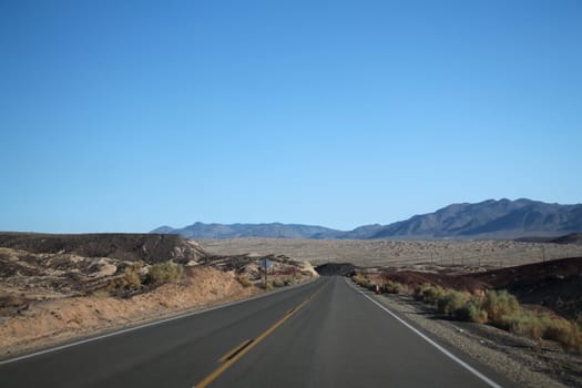 Death Valley road across the desert to the mountains in the distance. California, USA