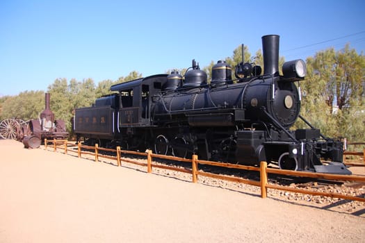 The traditional black locomotive of the gold rush in the Death Valley desert in California