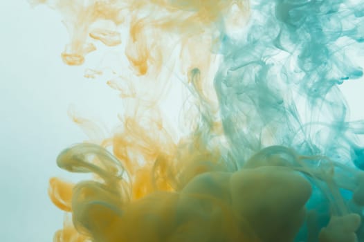Paint in the water. ink in fluid. abstract background. colorful splashes in liquid. yellow and blue colors