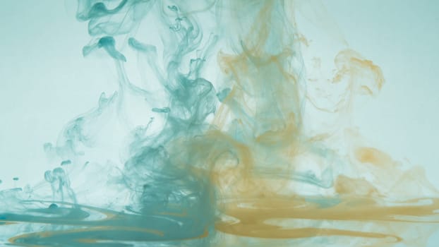 Paint in the water. ink in fluid. abstract background. colorful splashes in liquid. yellow and blue colors
