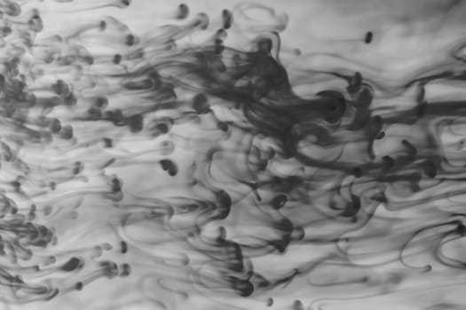 Ink in the water abstract background. splashes of paint swirling in liquid. black and white