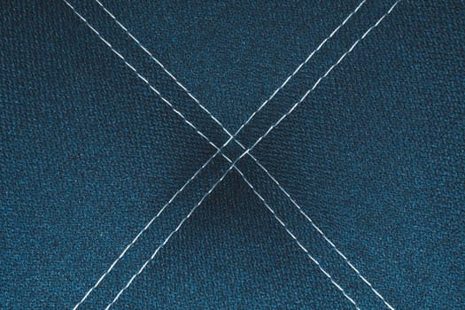 Dark blue denim background with white stitching close up background