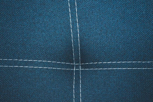 Dark blue denim background with white stitching close up background