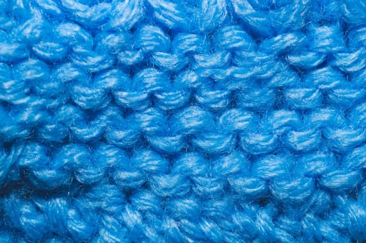 Knitted background close up. blue woolen fabric macro