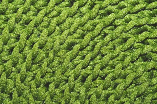 Knitted background close up. green woolen fabric macro