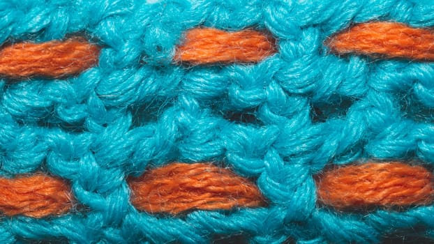 Blue woolen fabric with orange threads. knitted background close up
