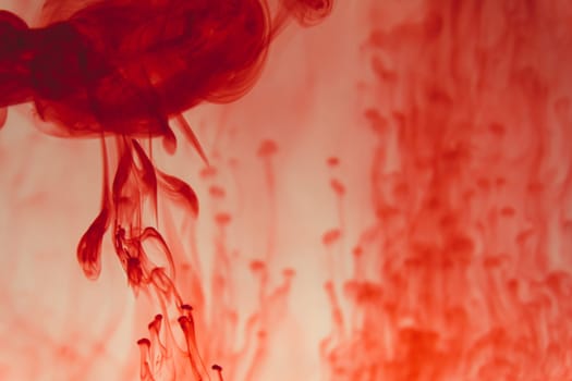 Red ink in the water abstract background. splashes of paint in liquid