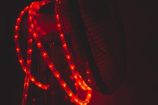 Garland of red light bulbs shines in the dark