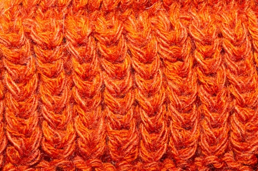 Knitted background close up. orange woolen fabric macro